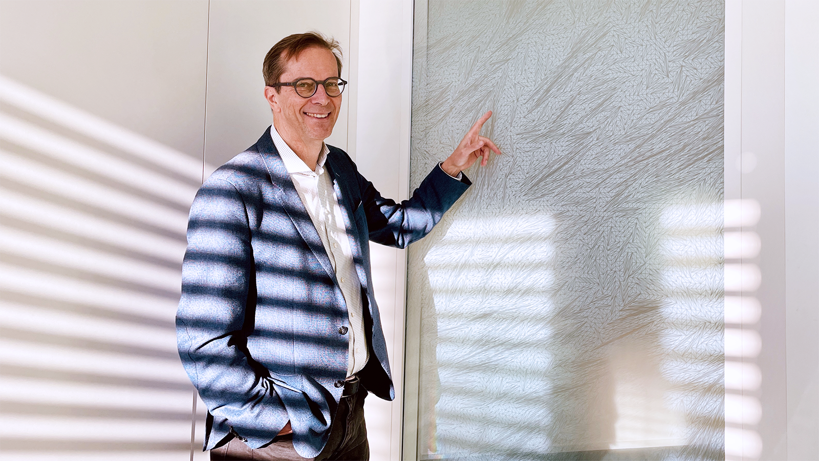 Professor Welzl stands in front of his window decorations and points to them.